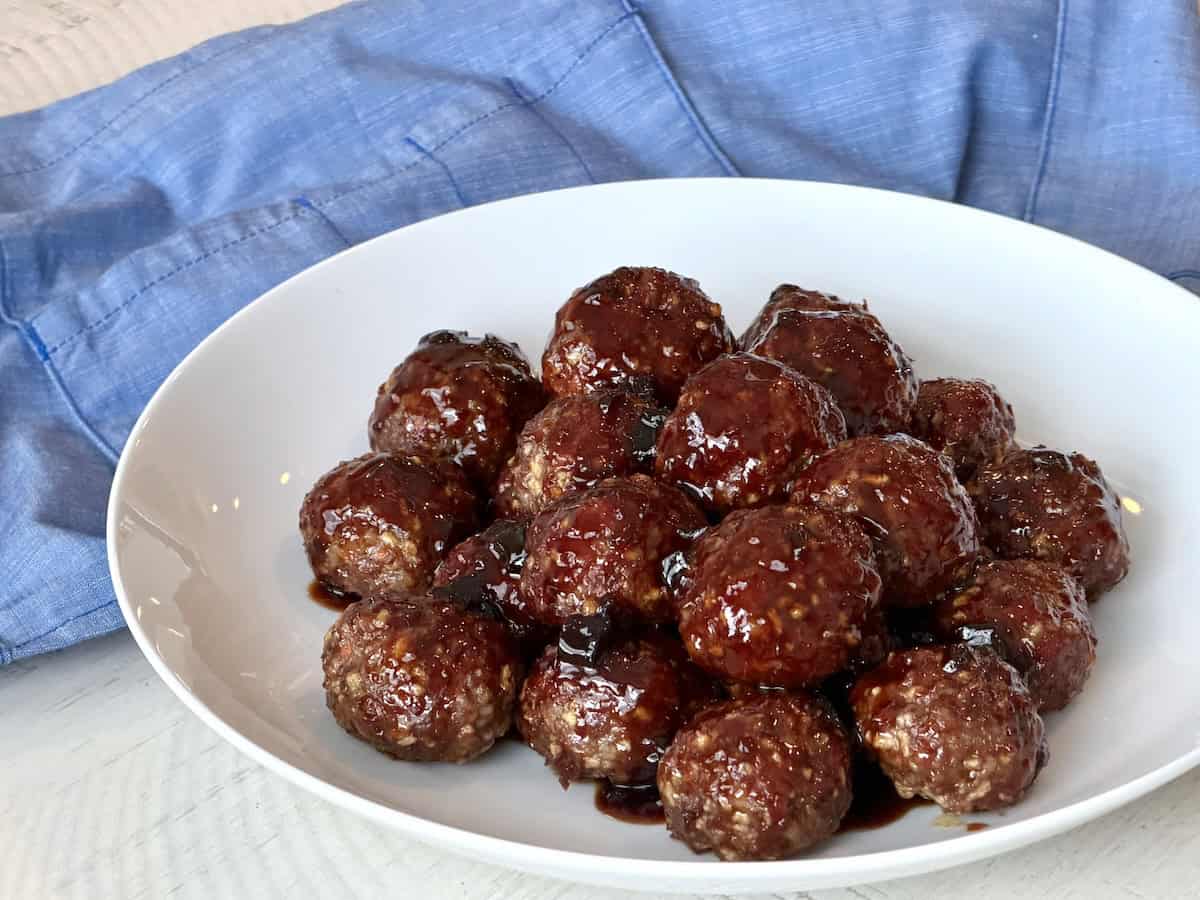 smoked meatballs on white plate with blue apron
