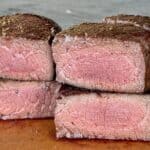 two filet mignon steaks cut in half on cutting board