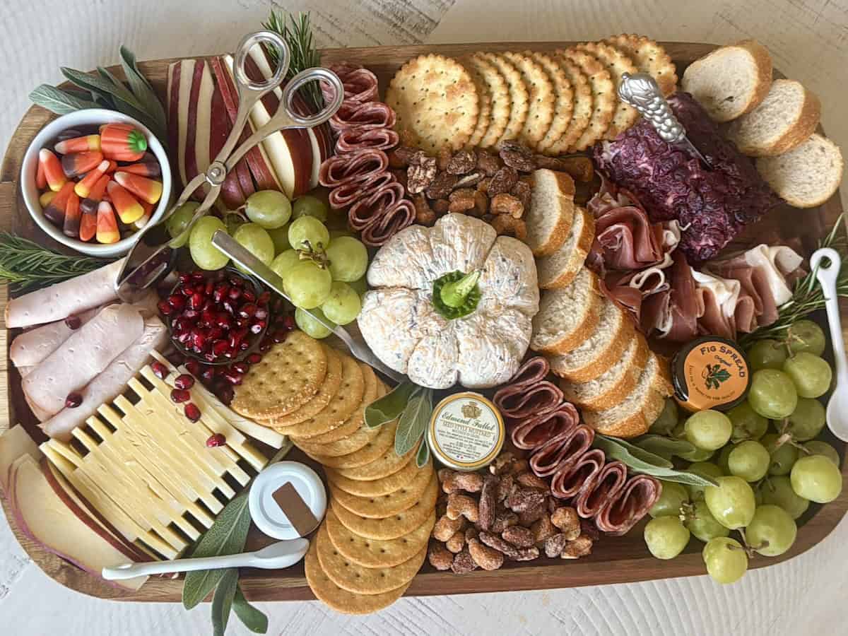 cheese ball crackers meats grapes and assorted charcuterie foods