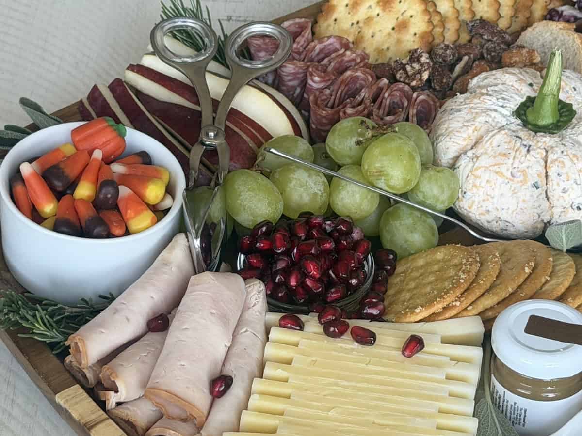 sliced cheese rolled turkey slices fruits candy in white bowl 