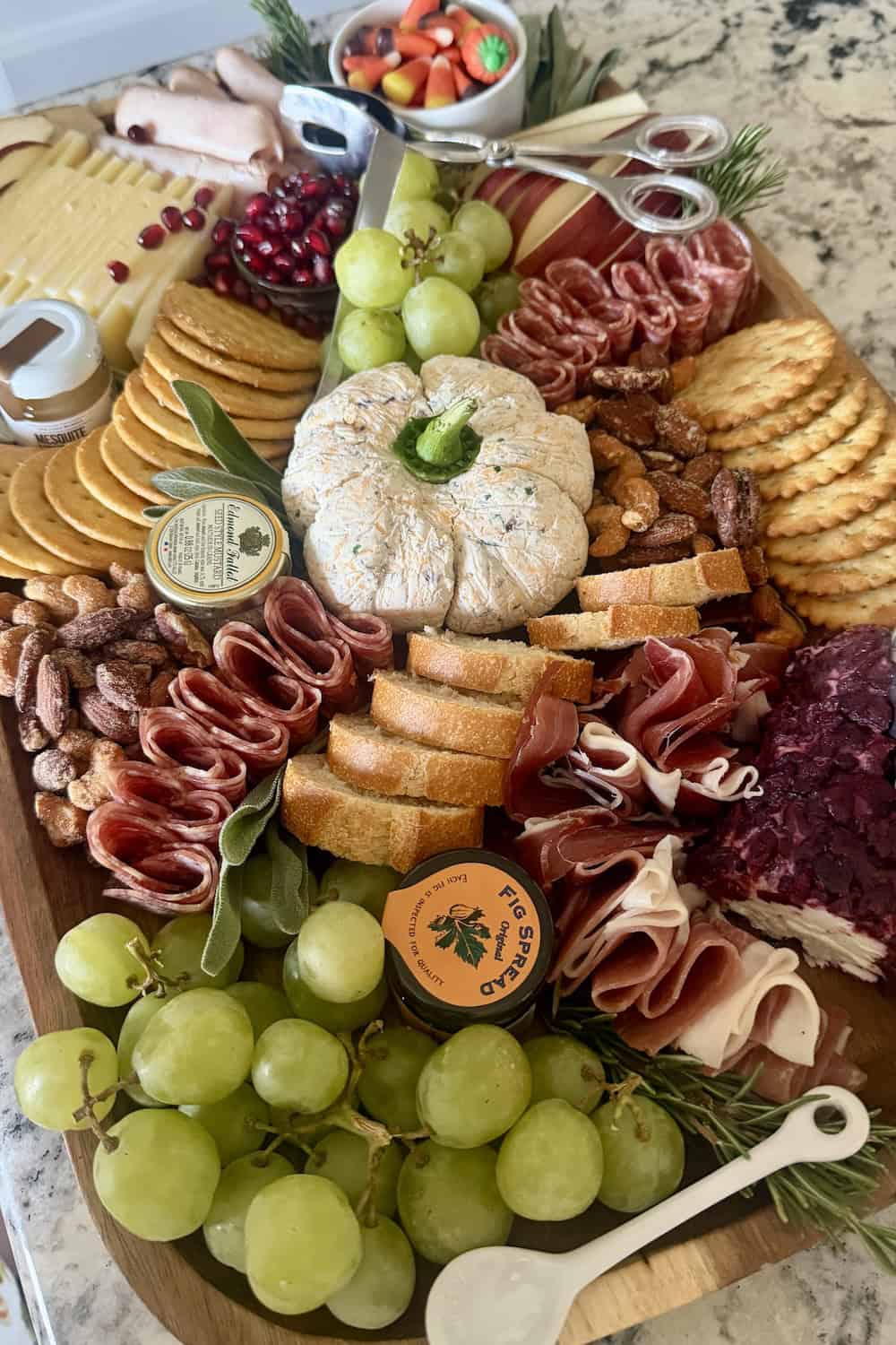 cheese ball crackers meats grapes and assorted charcuterie foods