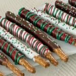 christmas chocolate dipped pretzel rods on white serving plate