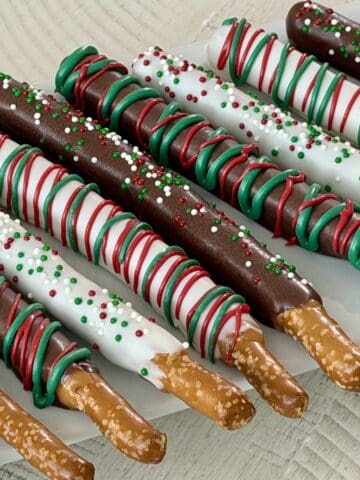 christmas chocolate dipped pretzel rods on white serving plate