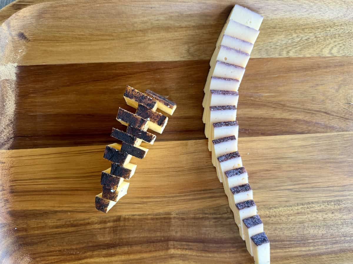 two aged cheddar cheeses with flavored edges sliced and styled