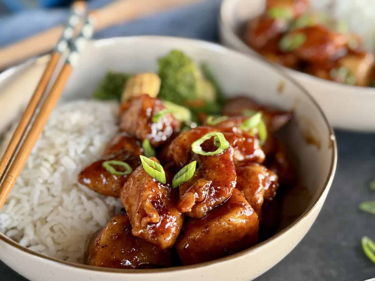 bourbon chicken served in bowl chopsticks