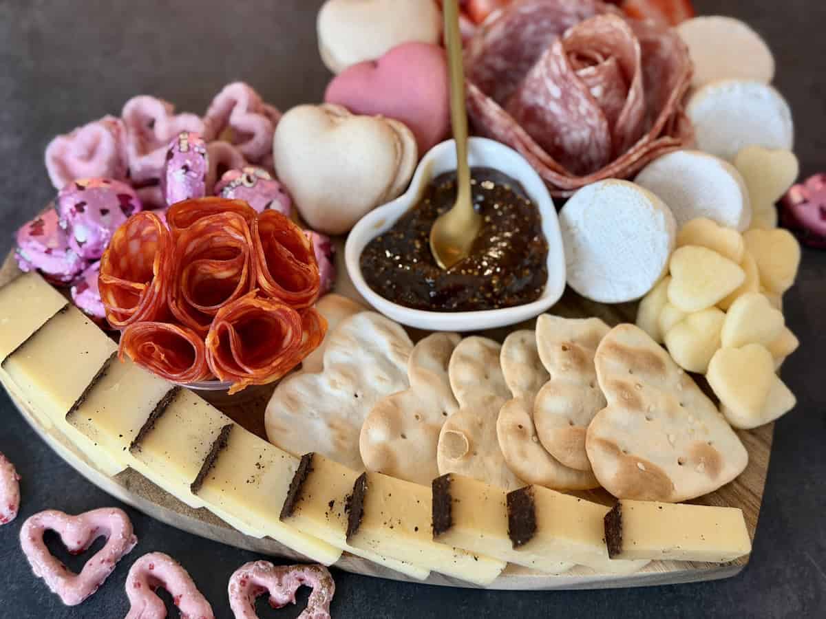 heart shaped charcuterie board cheese meat flowers macarons brie fig spread gold spoon