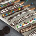 caramel and chocolate dipped pretzel rods variety of toppings white platter