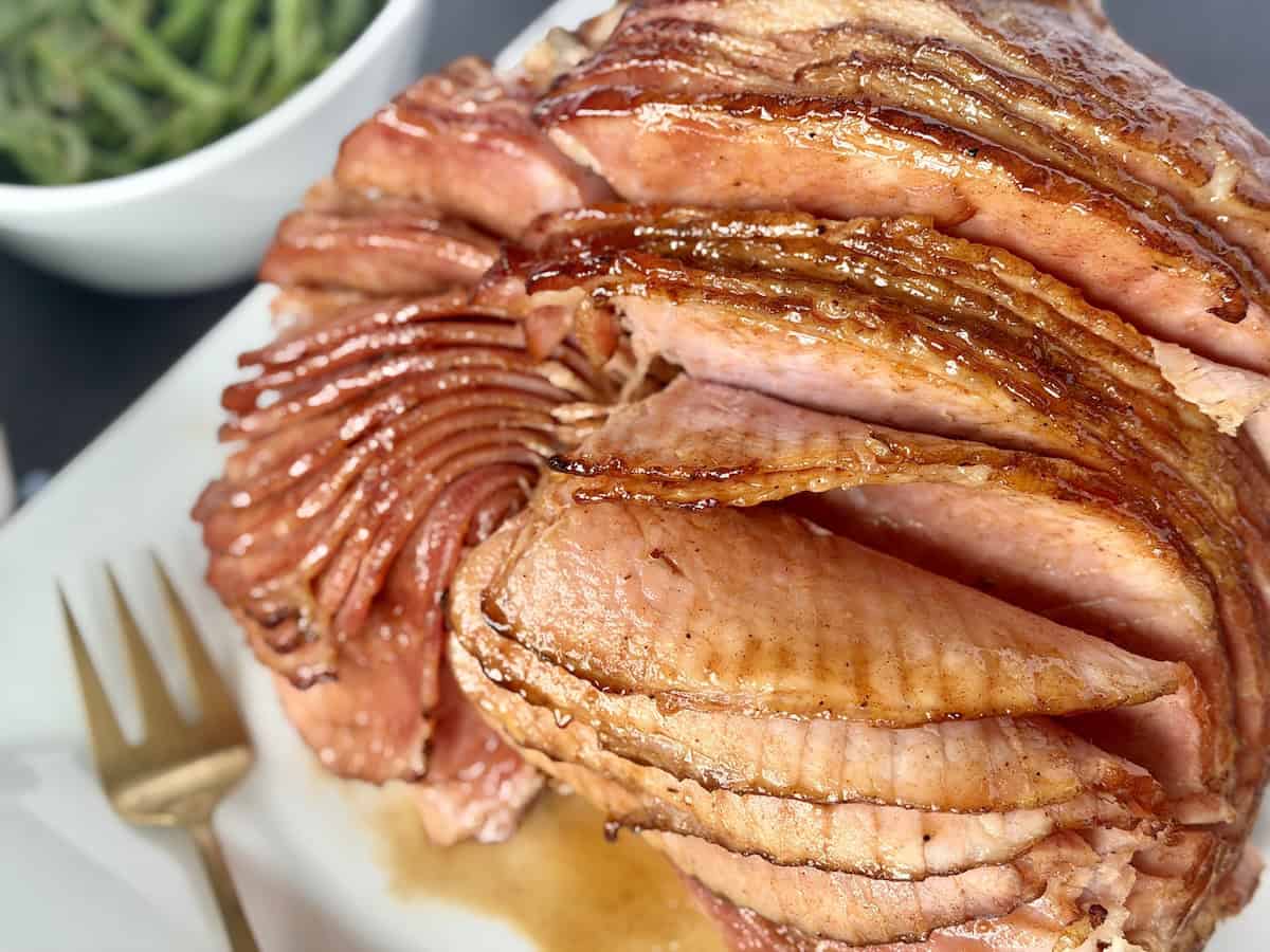 spiral ham on white plate gold fork