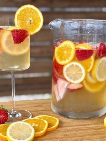 strawberry citrus sangria in a glass pitcher glass of sangria cut strawberries oranges lemons