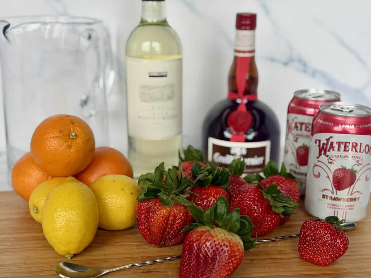 white wine sangria ingredients wood cutting board large glass pitcher