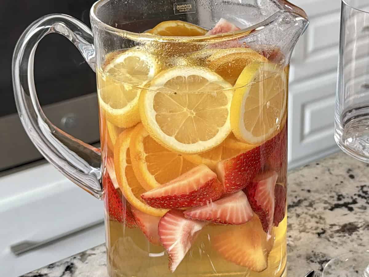 glass pitcher of sangria on marble kitchen countertop