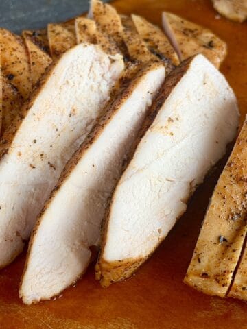 sliced traeger chicken breast on wood cutting board