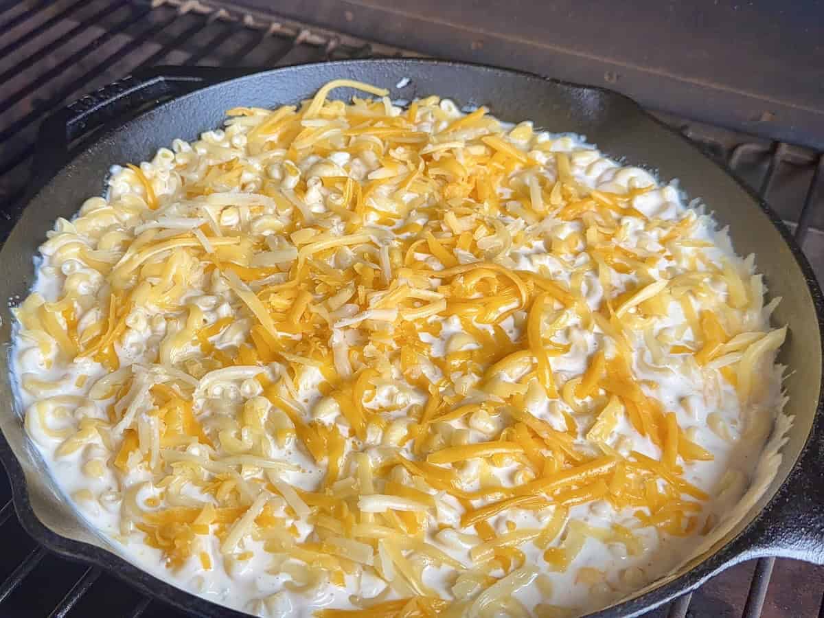 cast iron skillet of Mac and cheese on traeger grill grates