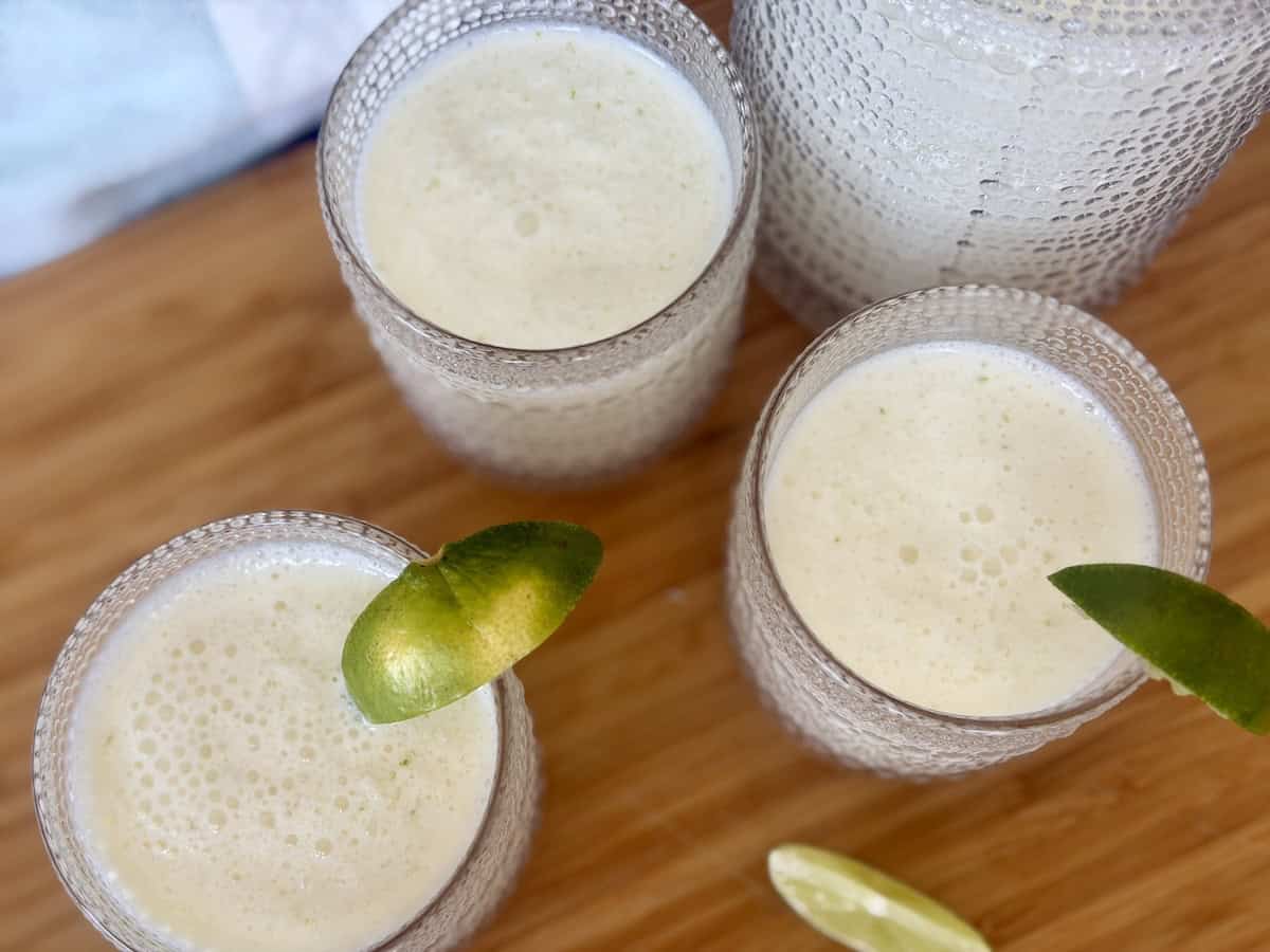 glasses on lemonade on wood cutting board garnished with limes