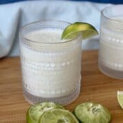 Brazilian lemonade in glass lime wedge squeezed lime halves