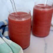 2 strawberry fruit slushies green kitchen towel white marble countertop