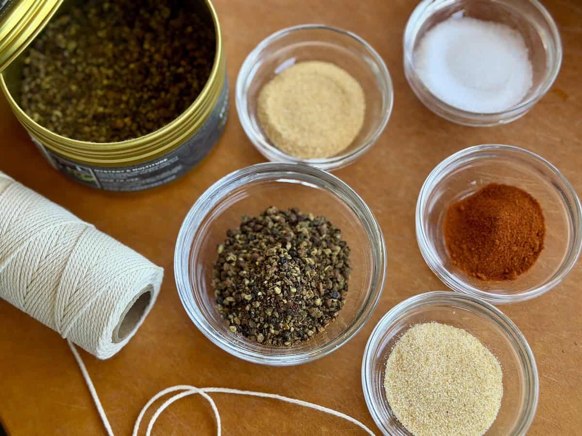 spices in glass bowls on cutting board roll of cooking string