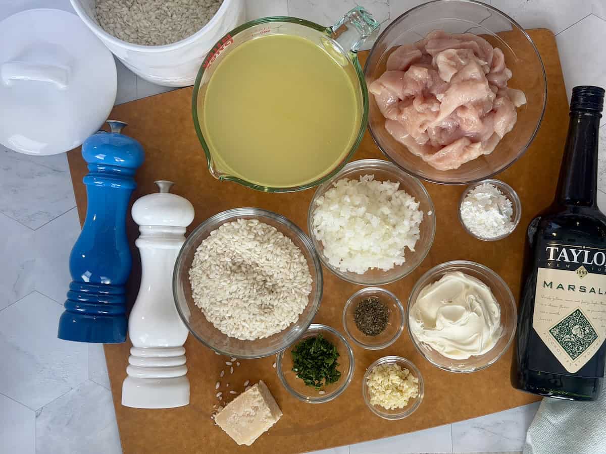 chicken marsala risotto ingredients measured in glass bowls on wood cutting board