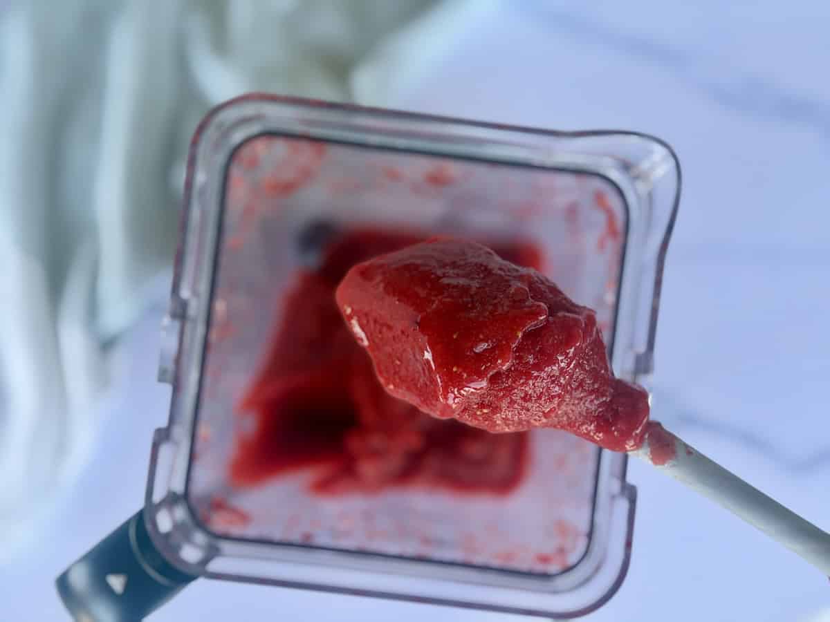 spatula scooping strawberry sorbet out of blender