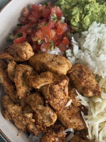 chipotle chicken with rice, guacamole, and pico de Gallo in a bowl