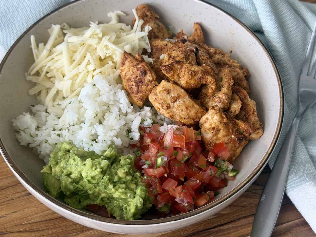 chipotle chicken with rice, guacamole, and pico de Gallo in a bowl