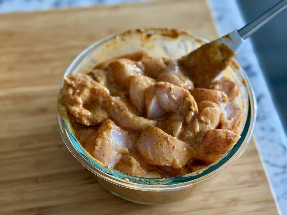 spatula stirring chicken in marinade